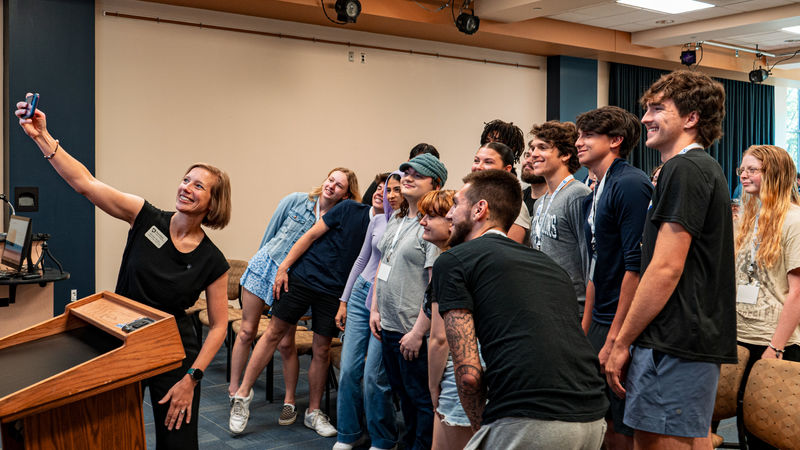 students gather around the chancellor for a group selfie at NSO